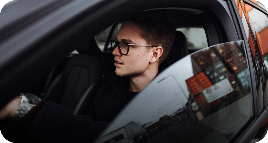jüngerer Mann mit Brille im Auto 
